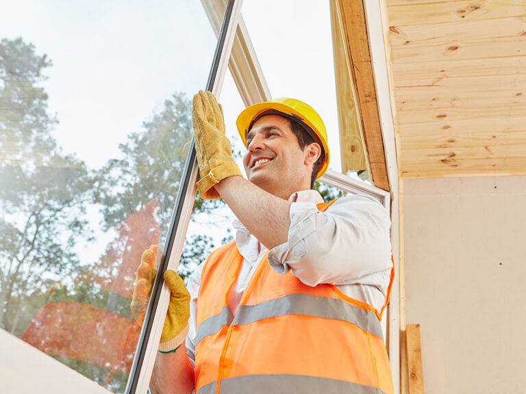 Ein Fensterbauer baut ein Fenster ein